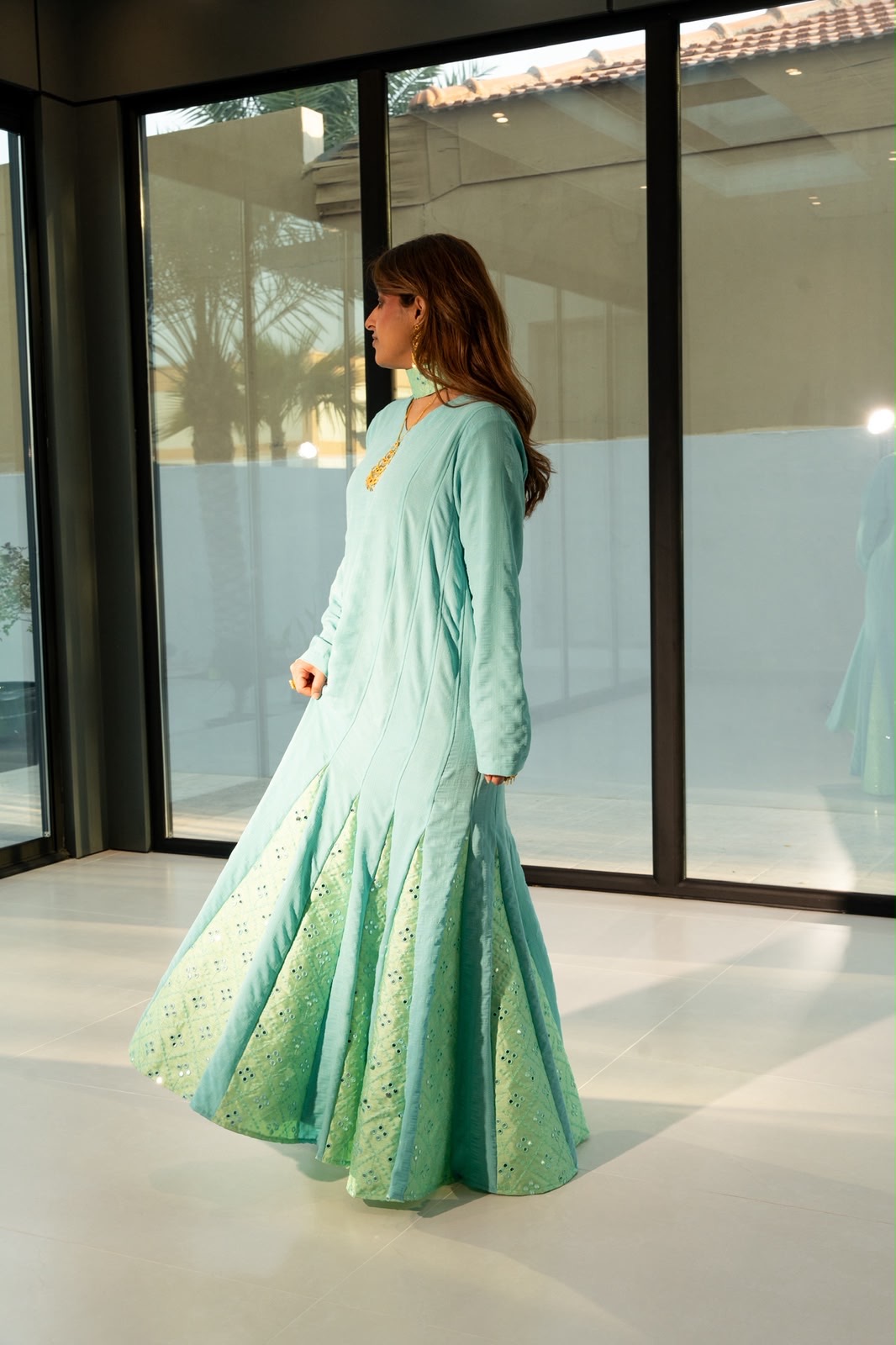 Mint kaftan in motion, showing pine green eyelet detailing on the sleeves