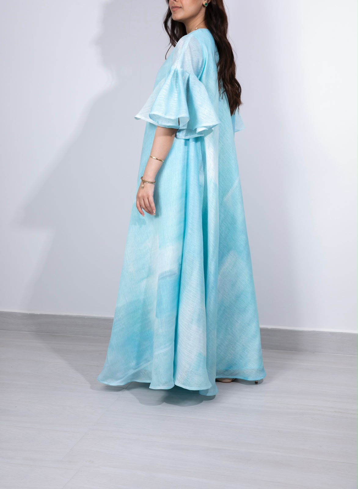 Side profile of the Appliqué Aqua Flutter kaftan showing flutter sleeve and flowing hem